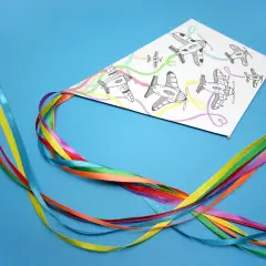 Kolorowy latawiec DIY z samolotami na tle niebieskim. Wstążki w tęczowych barwach tworzą ogon.