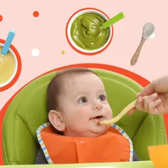 Uśmiechnięte dziecko w krzesełku do karmienia podczas rozszerzania diety. Na stole puree z warzyw i owoców, makaron.