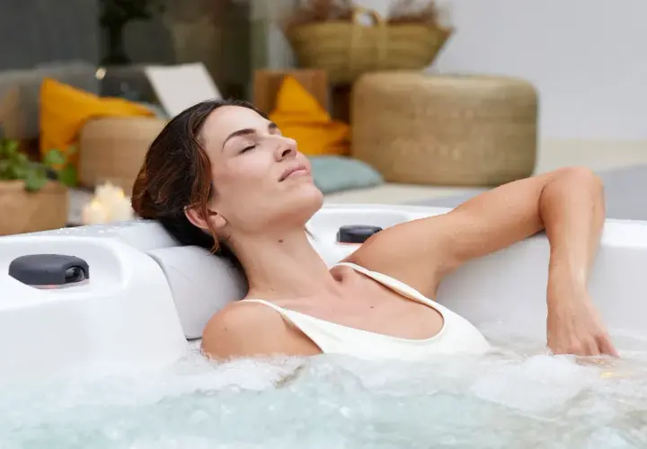 Kobieta w ciąży relaksuje się w jacuzzi, ciesząc się ciepłą wodą i bąbelkami. To chwila spokoju i odprężenia.