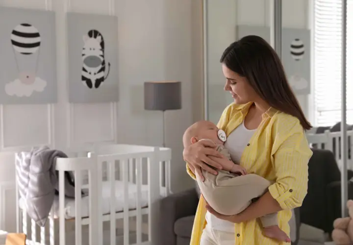 Mama tuli dziecko do snu w body i spodniach, pokazując, jak ubrać dziecko do snu bez śpiworku.