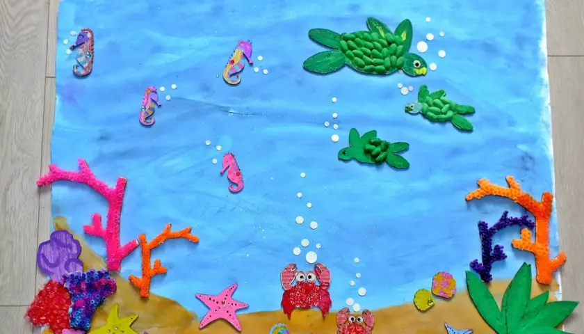 Kolorowa praca plastyczna "Ocean" z konikami morskimi, żółwiami, krabami i koralowcami.