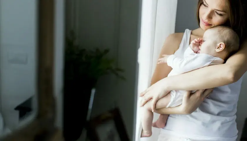 Mama tuli otula niemowlę w domu, gdy jest 25 stopni. Jak ubrać niemowlaka w taki upał? Lekka bawełna to klucz.