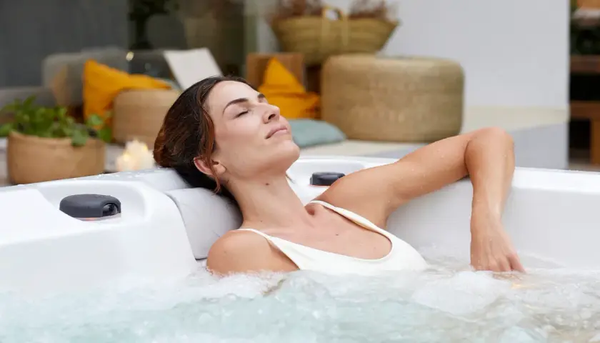 Kobieta w ciąży relaksuje się w jacuzzi, ciesząc się ciepłą wodą i bąbelkami. To chwila spokoju i odprężenia.