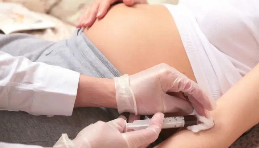 Przygotowanie do zastrzyku z immunoglobuliny. Ręce w rękawiczkach przygotowują zastrzyk dla kobiety w ciąży.