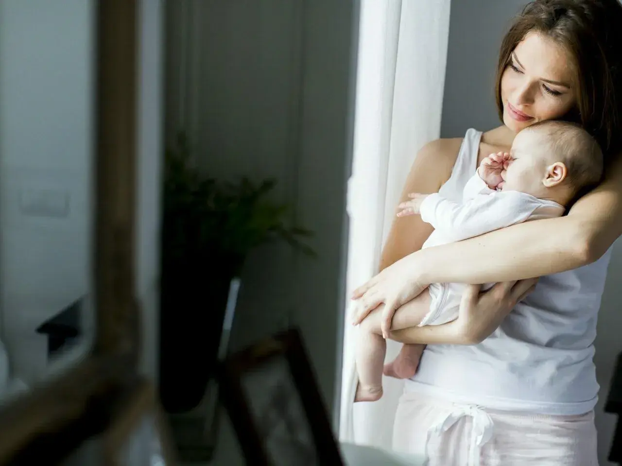 Mama tuli otula niemowlę w domu, gdy jest 25 stopni. Jak ubrać niemowlaka w taki upał? Lekka bawełna to klucz.