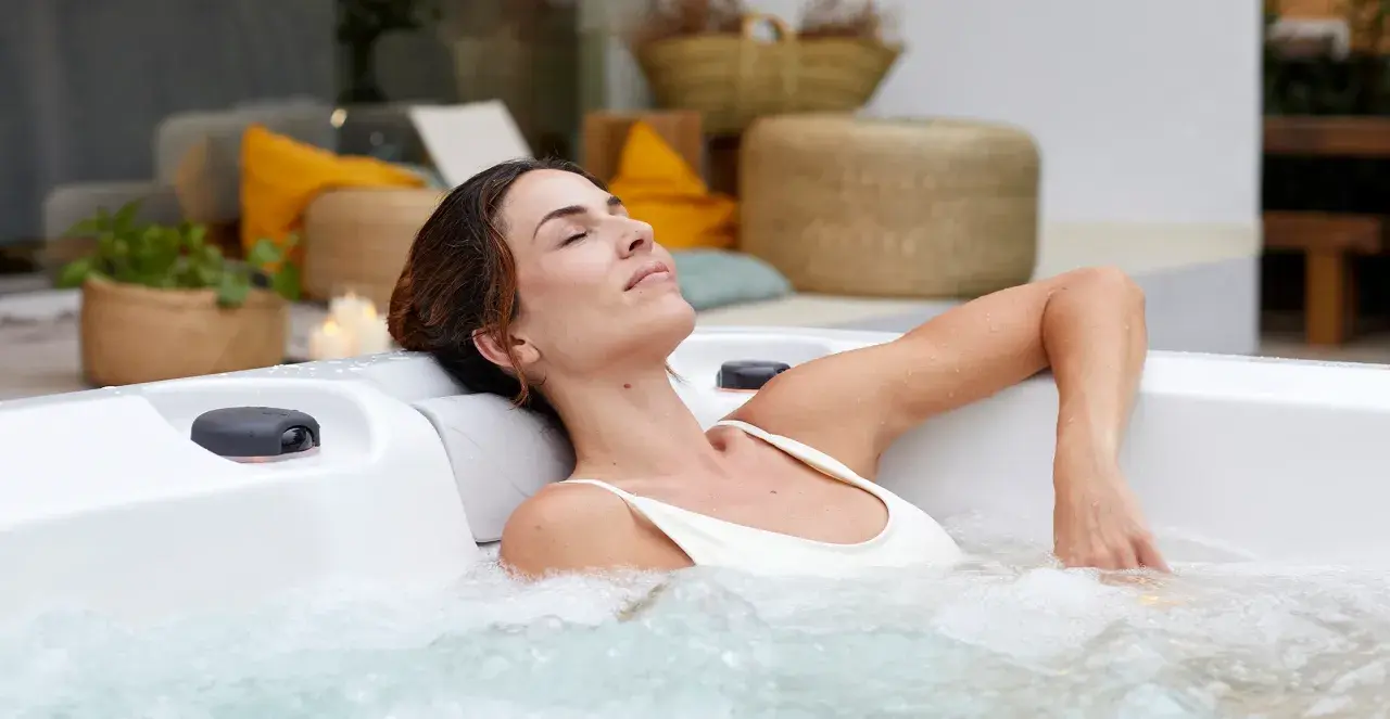 Kobieta w ciąży relaksuje się w jacuzzi, ciesząc się ciepłą wodą i bąbelkami. To chwila spokoju i odprężenia.
