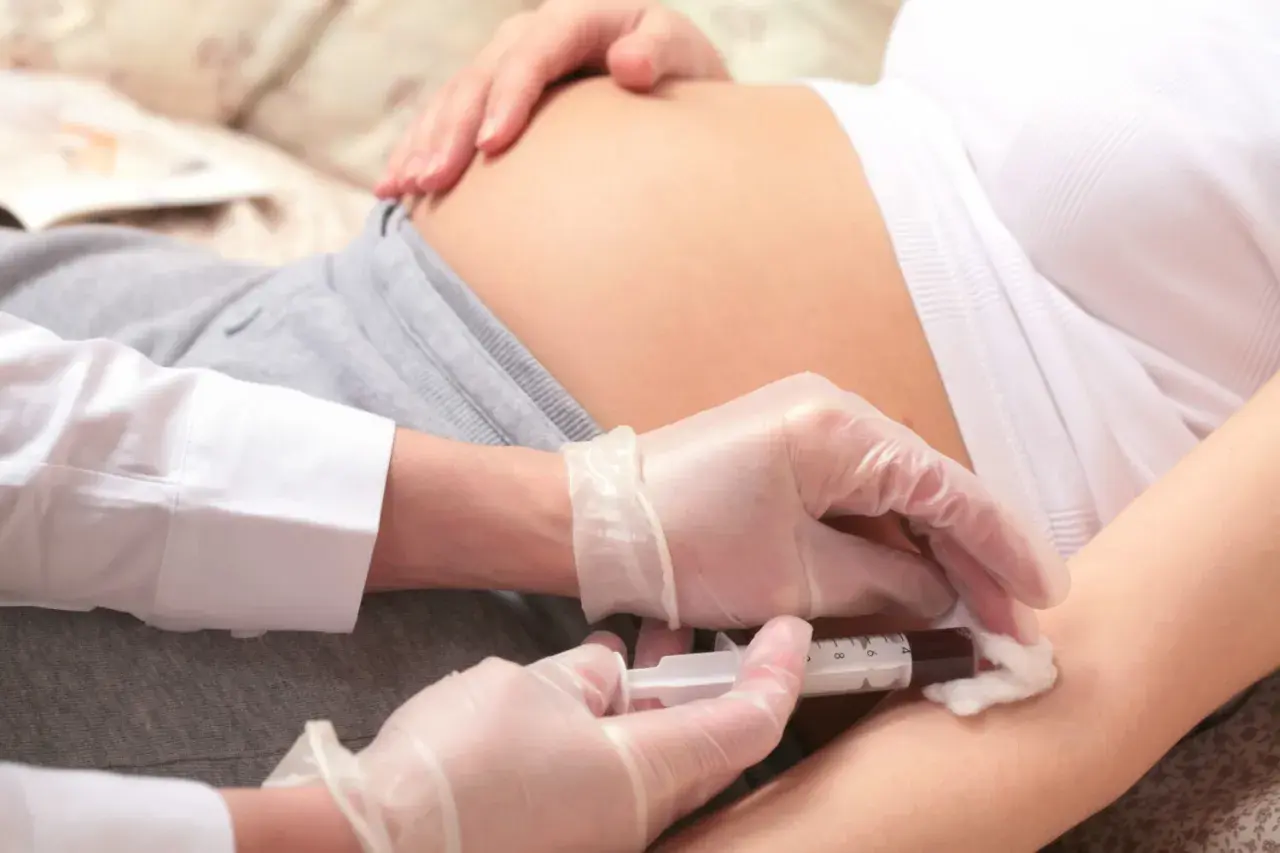 Przygotowanie do zastrzyku z immunoglobuliny. Ręce w rękawiczkach przygotowują zastrzyk dla kobiety w ciąży.