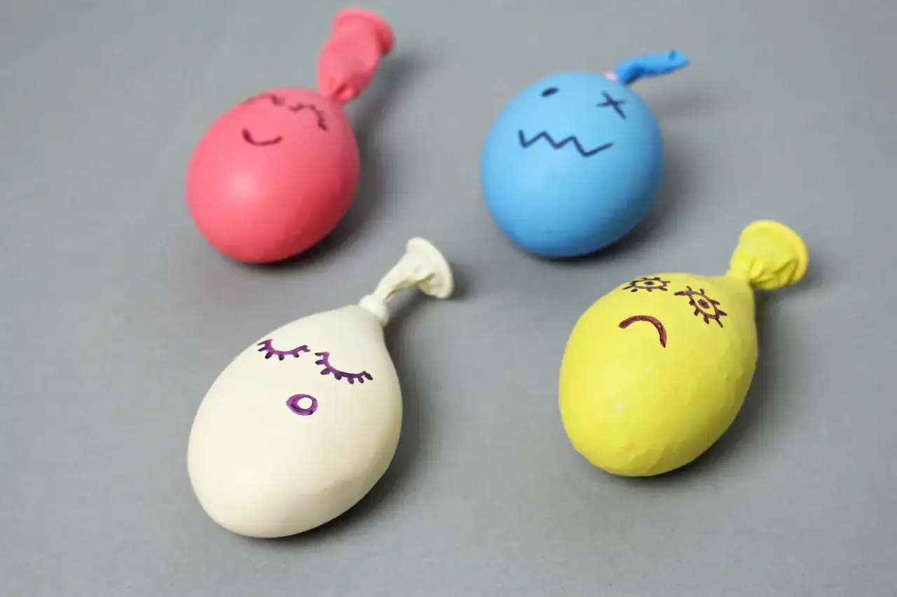 Kolorowe balony z narysowanymi buźkami, gotowe do zabawy. Proste jak zrobić gniotka!